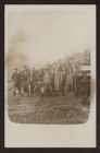 Uniformed soldiers standing next to railway cars